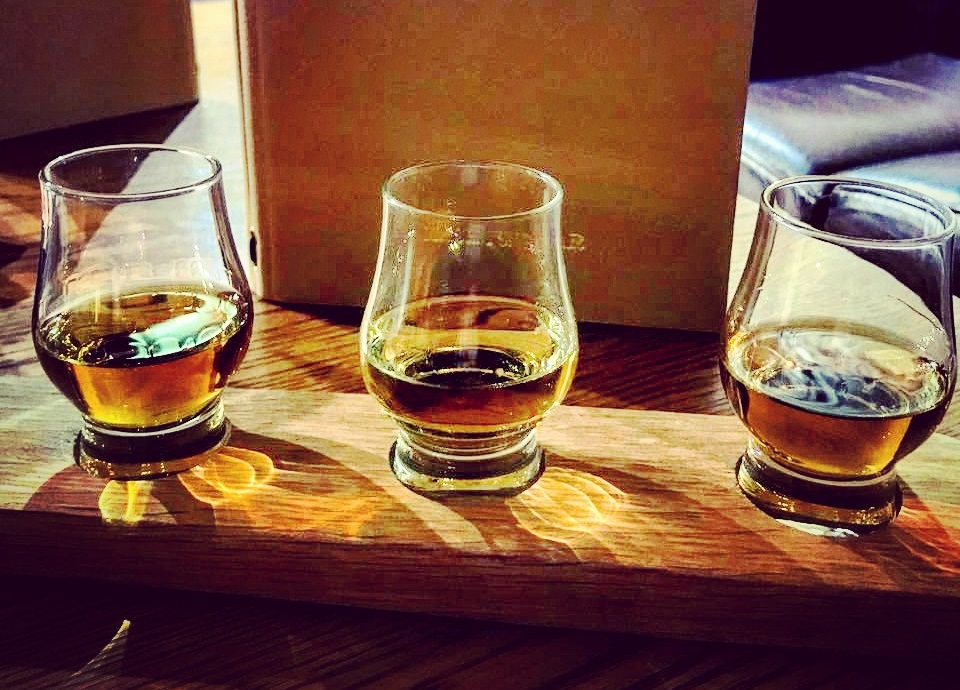 Whisky Tasting aus drei Drams präsentiert auf einem Holzbrett